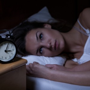 Picture of a woman with insomnia who can't sleep, she is wide awake in the middle of the night at 3 a.m.