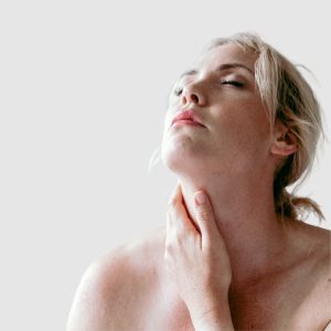 picture of a woman holding her neck wondering about doing thyroid tests for hypothyroid or hyperthyroid or Grave's disease or Hashimoto's